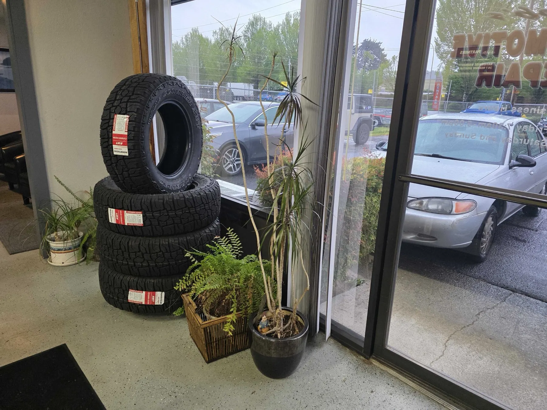 All-terrain tires stacked at Rob's Automotive Repair Center customer entrance in Clackamas, Oregon